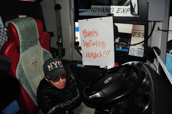 서기현 장애인자립생활센터 '판' 소장이 몸에 쇠사슬을 두르고 버스 운전석에 앉아있다.