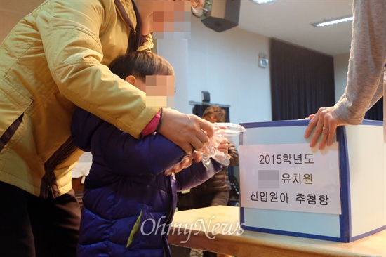 4일 서울 영등포구의 한 유치원에서 한 어린이가 보호자와 함께 입학 추첨을 하고 있다. 