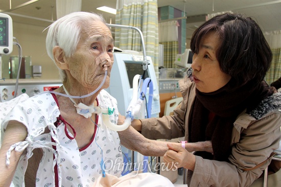 일본군위안부 피해자 이효순(90) 할머니가 창원의 한 병원 중환자실에 입원해 있는데, 5일 오전 이경희 '일본군위안부할머니와함께하는 마창진시민모임' 대표가 찾아와 건강 상태를 살피며 말을 건네고 있다.