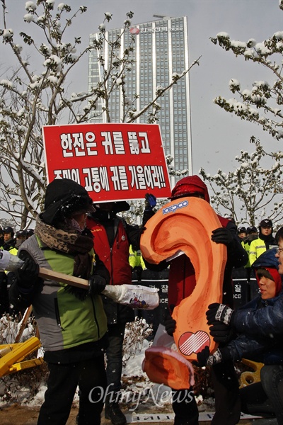 한국전력공사 이전 기념식이 17일 오후 2시 40분 전남 나주 한국전력공사 신사옥에서 열린 가운데 경북 청도, 경남 밀양에서 송전탑 건설 반대 운동을 벌이고 있는 마을 주민 할머니·할아버지들이 나주를 찾아 "송전탑 철거를 약속하라"고 요구했다. 집회 중 할머니들이 한국전력이라고 적힌 귀의 귓구멍을 뚫는 퍼포먼스를 선보이고 있다.