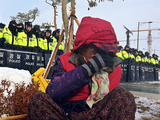 한국전력공사 이전 기념식이 17일 오후 2시 40분 전남 나주 한국전력공사 신사옥에서 열린 가운데 경북 청도, 경남 밀양에서 송전탑 건설 반대 운동을 벌이고 있는 마을 주민 할머니·할아버지들이 나주를 찾아 집회를 열고 "송전탑 철거를 약속하라"고 요구했다. 집회 도중 한 할머니가 차를 마시며 몸을 녹이고 있다.