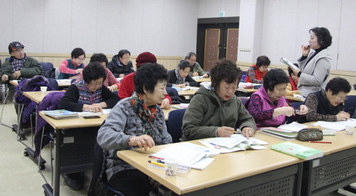  열우물 한글배움터 학생들이 박진숙 교사의 설명을 들으며 공부에 열중하고 있다.