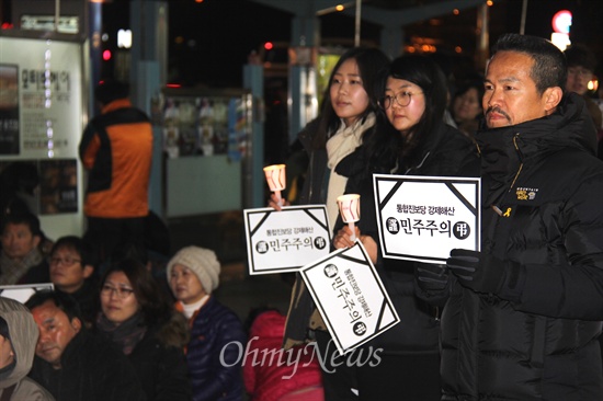 19일 저녁 창원 정우상가 앞에서 열린 "근조 민주주의, 민주수호 경남촛불문화제"에서 참가자들이 촛불과 피켓을 들고 서 있다.