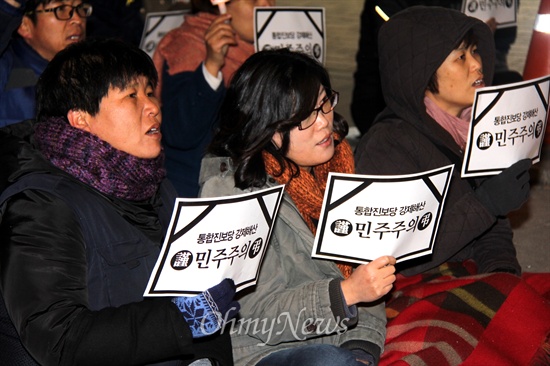  19일 저녁 창원 정우상가 앞에서 열린 "근조 민주주의, 민주수호 경남촛불문화제"에서 참가자들이 촛불과 피켓을 들고 앉아 있다.