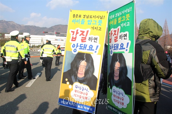  친환경무상급식지키기 경남운동본부가 19일 오후 창원 만남의 광장에서 "우리 아이 밥그릇 지키지 한마음 대행진"을 연 뒤 경남도청 앞까지 거리행진했다. 사진은 참가자들이 홍준표 지사를 비난하는 '등벽보'를 만들어 경남도청 정문 앞을 걸어가는 모습.