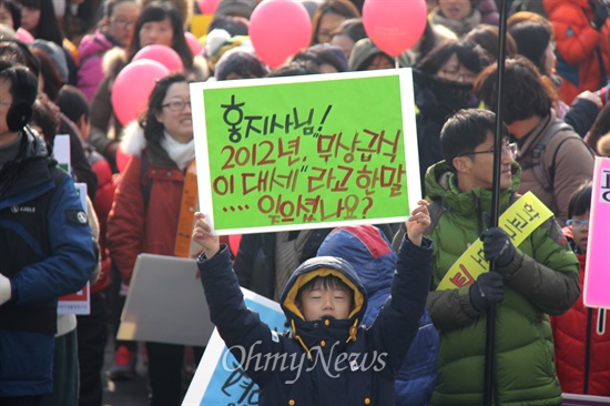 친환경무상급식지키기 경남운동본부가 19일 오후 창원 만남의 광장에서 "우리 아이 밥그릇 지키지 한마음 대행진"을 연 뒤 경남도청 앞까지 거리행진했다. 사진은 한 아이가 홍준표 지사와 관련한 피켓을 들고 서 있는 모습.