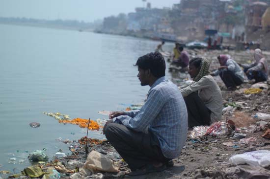 쓰레기로 너저분한 갠지스 강가에서 낚시 줄을 던져 놓고 있는 인도 사람들
