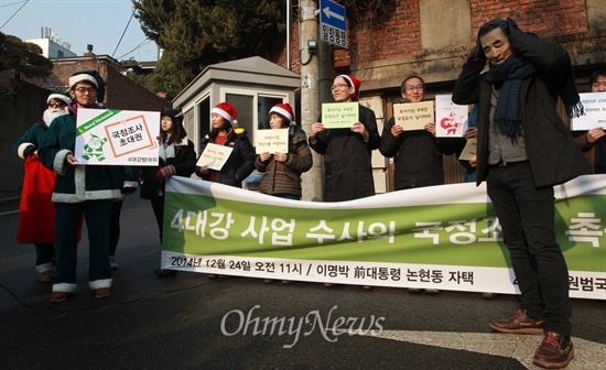 이명박 전 대통령 크리스마스 선물은? 환경운동연합과 녹색연합 등 민간 전문가들로 구성된 '4대강복원범국민대책위원회 4대강조사위원회' 소속 회원들이 24일 오전 서울 강남구 이명박 전 대통령 자택 인근에서 기자회견을 열어 4대강 사업 수사와 국정조사를 촉구하고 있다.
이날 이들은 크리스마스를 앞두고 산타복장을 한 채 잘못된 운하사업에 대한 책임을 촉구하며 크리스마스 선물로 국정조사 초대권과 녹조라떼, 큰빗이끼벌레 등이 찍힌 사진을 전달하는 퍼포먼스를 벌였다.
이들은 "천문학적인 액수의 혈세를 낭비하고 4대강을 망가뜨린 장본인이 이명박 전 대통령이다"며 "우리에게 선물로 남긴 것은 죽어가는 강과 빚더미의 대한민국 뿐이다"고 주장했다.