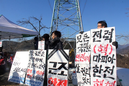  한국전력공사가 오는 28~29일 '신고리-북경남 765kV 송전선' 시험송전에 들어갈 예정인 가운데, 밀양765kV송전탑반대대책위는 26일 밀양시 상동면 고정리 370번지에 있는 '115번 철탑' 앞에서 "송전 저지 농성"에 들어갔는데, '신경기변전소와 송전탑반대 광주여주시민연대' 회원들이 참석해 피켓을 들고 서 있다.