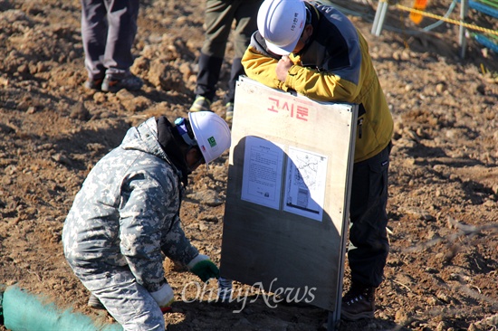  한국전력공사가 오는 28~29일 '신고리-북경남 765kV 송전선' 시험송전에 들어갈 예정인 가운데, 밀양765kV송전탑반대대책위는 26일 밀양시 상동면 고정리 370번지에 있는 '115번 철탑' 앞에서 "송전 저지 농성"에 들어갔는데, 한전 관계자들이 고시문을 설치하고 있다.