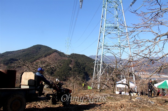  한국전력공사가 오는 28~29일 '신고리-북경남 765kV 송전선' 시험송전에 들어갈 예정인 가운데, 26일 밀양시 상동면 고정리 370번지에 있는 '115번 철탑' 아래에서 과수원 주인이 경운기로 농삿일을 하고 있다.