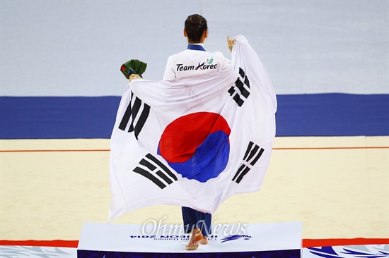 10월 2일 인천아시안게임 리듬체조에서 한국 최초로 금메달리스트가 손연재, 시상대에 올라서 태극기를 두르고 있다. 