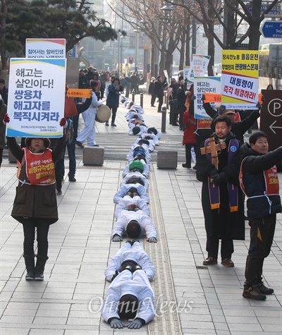 1월 11일, 금속노조 쌍용자동차 해고노동자와 연대단체 참가자들이 비정규직 법·제도 철폐를 위한 오체투지 행진을 벌이고 있다. 
