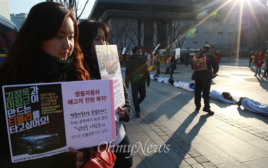 금속노조 쌍용자동차 해고노동자와 연대단체 참가자들이 11일 오후 서울 종로구 세종문화회관을 지나며 비정규직 법·제도 철폐를 요구하는 오체투지를 벌이자, 시민들이 이들을 응원하는 손피켓을 들어보이고 있다.