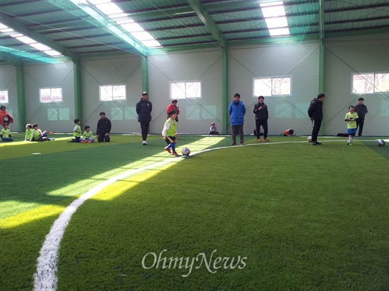  초등학교 학생들이 스포츠강사의 지도로 축구 연습을 하고 있는 모습.