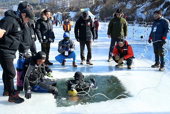 축제 참가자들의 안전을 보장하기 위해 빙판 안전 점검에 나선 잠수부들.