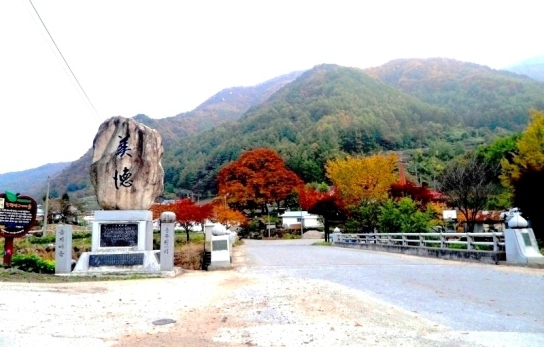 마을 입구에 '미덕'이라고 쓴 비석과 다리가 나온다.