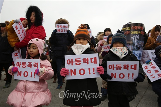 어린이집 아동학대 파문이 확산되는 가운데 18일 오후 인천 송도 센트럴파크에서 '송도국제도시맘'과 '송도주민연합회' 회원들이 아동폭력·아동학대 추방과 보육환경 개선 촉구 집회를 열었다. 부모와 아이들이 함께 손피켓을 들고 있다.