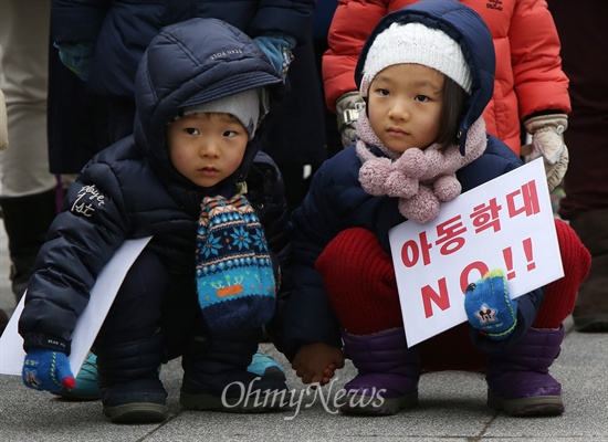 손을 꼭 잡은 남매가 어른들의 발언을 관심있게 듣고 있다.