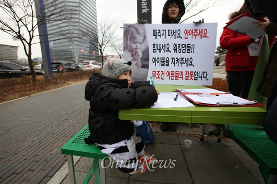 집회가 열리는 송도 센트럴파크 입구에 마련된 서명대에 한 어린이가 앉아 놀고 있다.