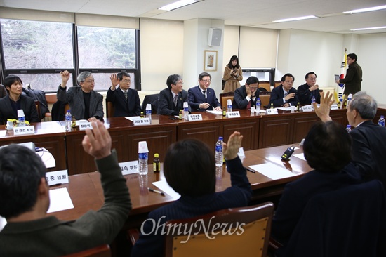 회의 공개 여부를 두고 참석자들이 손을 들어 투표를 하고 있다.