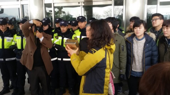 할머니들이 준비한 도시락을 전달하지 못하자 학부모연대 이단비대표가 할머니들이 만든 도시락을 들고 상황 설명을 하고 있다.