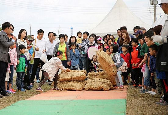 부모를 따라 시간여행에 참가한 아이들이 ‘쌀가마 나르기’ 체험을 하고 있다.(2014년 10월) 
