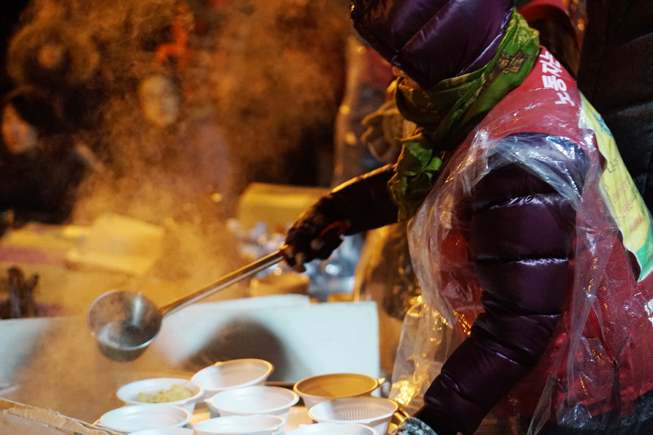 추운 날씨에 연대하러 온 시민대책위 회원 등에게 나눠줄 어묵탕을 생탁노동자가 끓여서 그릇에 담고 있다.
