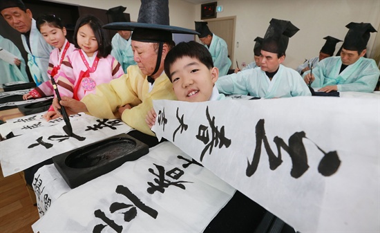 함양향교의 서예반 어르신들과 학생들이 함께 ‘입춘대길 건양다경(立春吉運 建陽多慶)’ 입춘첩을 쓰고 있다.
