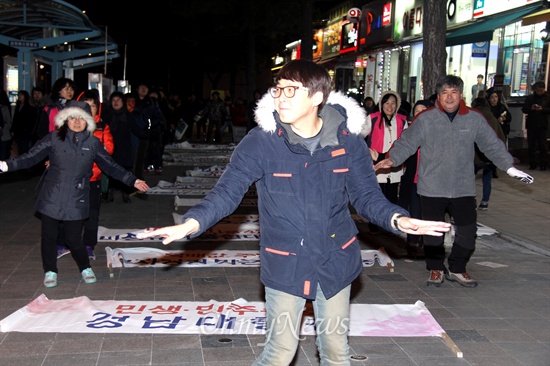 30일 저녁 창원 정우상가 앞에서 열린 '민생-민주수호 경남대행진'에 참가한 시민들이 노래 "바위처럼"에 맞춰 율동을 하고 있다.
