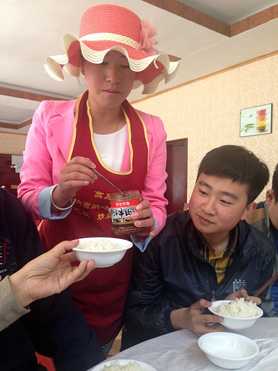 알바를 하는 중국 여대생. 식사를 하는 손님들에게 장을 덜어 주고 있다.