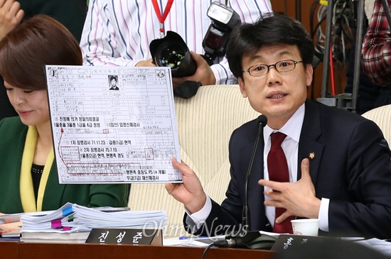 진성준 새정치민주연합 의원이 10일 이완구 국무총리 후보자에 대한 국회 인사청문회에서 이 후보자의 병적기록표를 들고 병역기피 의혹을 제기하고 있다.