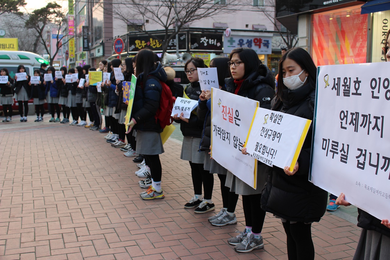목포하당 장미의 거리에서 고등학생들이 손 피켓을 들고 세월호 도보 행진단과 함께하고 있다.