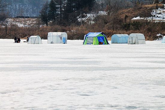 북한강 위에 텐트를 치고 빙어를 낚는 사람들. 얼음이 녹을 시기가 다가오고 있다. 지금 빙어잡이를 나서는 것은 상당히 위험한 일이다.