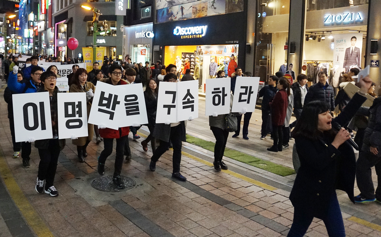 민주부산행동(준) 회원들이 "이명박을 구속하라"피켓을 들고 행진하고 있다.