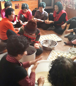 지난 12일 상장2리 부녀회원들이 노인정에 둘러앉아 간식으로 먹을 찐빵을 만들고 있다. 