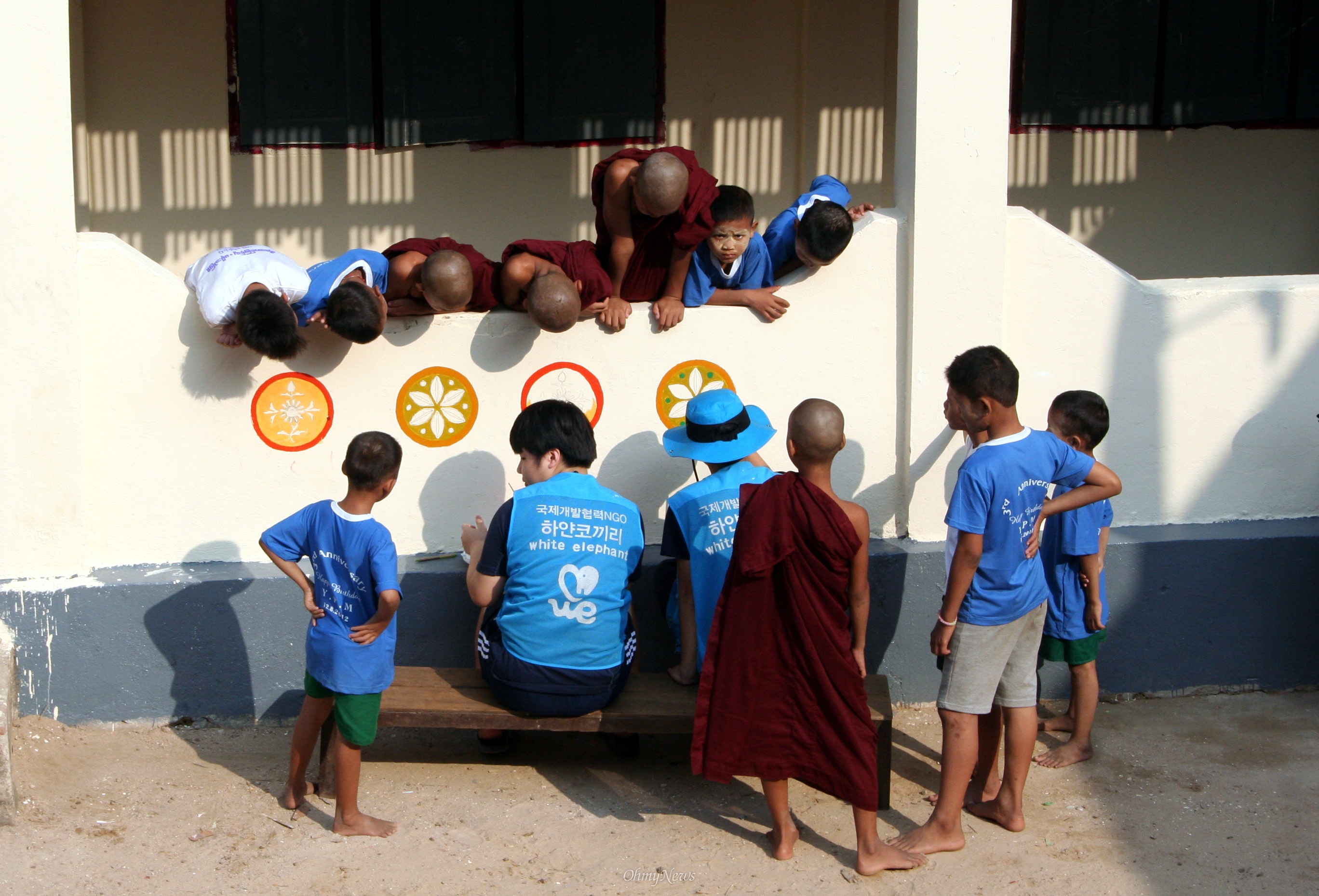 빤찬콩 보육원 아이들이 하얀 코끼리 자원봉사자들이 그리는 벽화를 유심히 쳐다보고 있다.