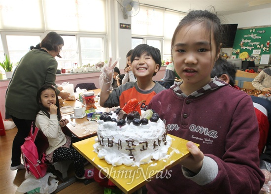 부명초등학교 2학년 1반 학생이 부모님에게 감사의 마음을 전하기 위해 손수 만든 케익을 들어보이고 있다.