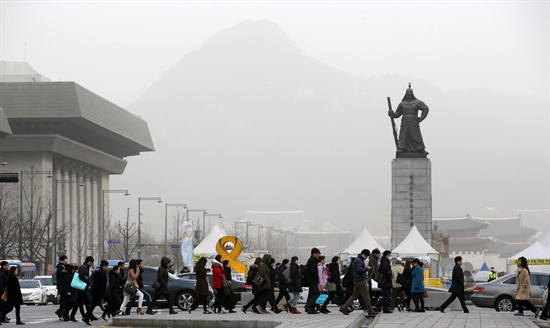 설 연휴가 끝난 뒤 맞는 첫 평일인 23일 중국발 황사가 한반도를 뒤덮은 가운데 서울 종로구 세종로네거리에서 시민들이 출근길을 서두르고 있다.