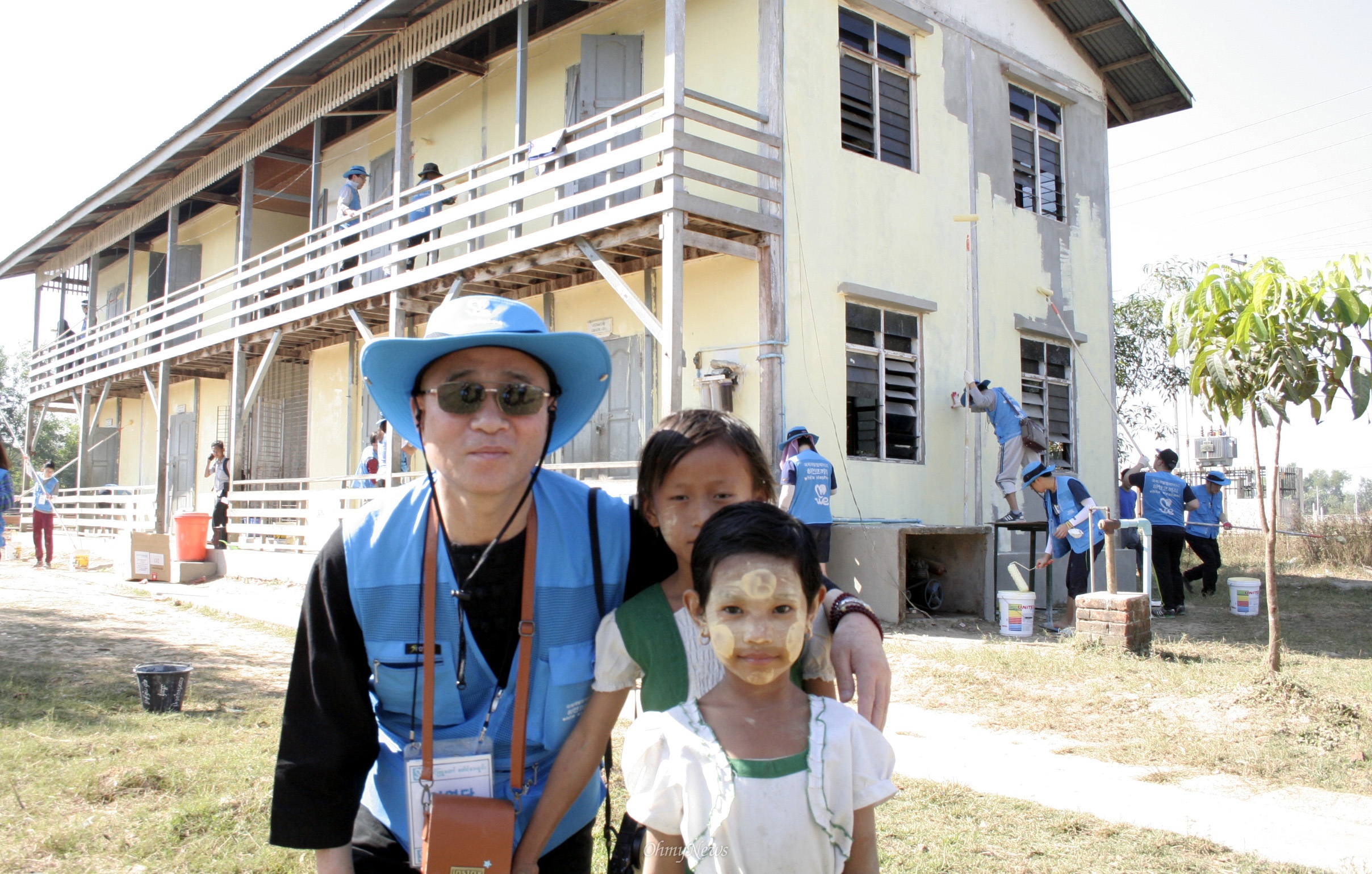 영담 스님이 미얀마 딴린의 수투판 고아원 아이들과 함께 페인트칠하는 건물 앞에서 포즈를 취했다.