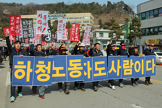 동양시멘트 사내하청업체 노동자 집단 해고 규탄대회. "하청 노동자도 사람이다" 펼침막을 들고 거리행진을 하고 있는 노동자들.