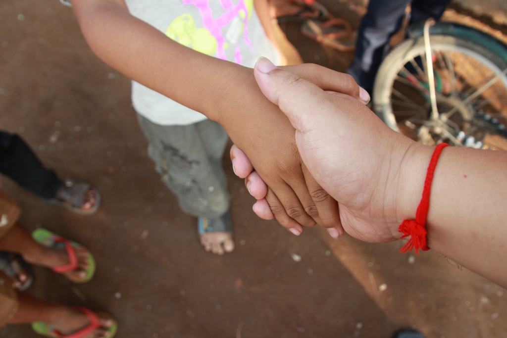 캄보디아 현지 고아원을 방문, 아이와 손을 잡은 봉사자. 아동심리전문가들은 아무리 좋은 시설을 갖추고 있더라도 세상에 좋은 고아원은 없다고 강조한다. 