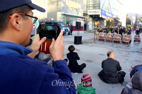 민주노총일반노동조합 창원시립예술단지회가 26일 오후 창원 정우상가 앞에서 연 "시립예술단 정상화를 기원하는 거리 공연"을 지나가던 시민이 휴대전화로 동영상 촬영하고 있다.