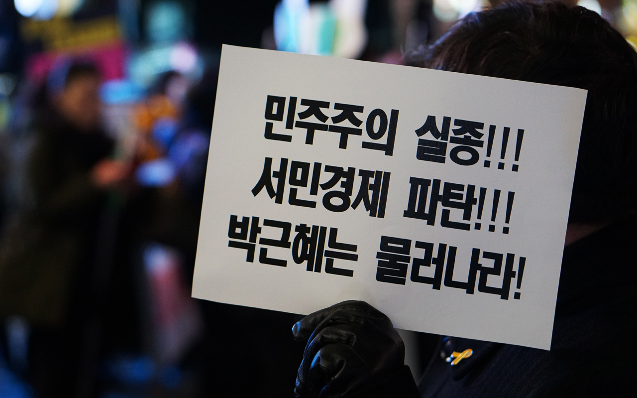 행진 참가자가 박근혜 정권규탄 피켓을 들고 있다.