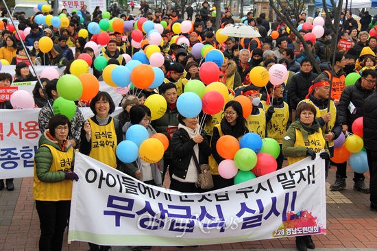  2월 28일 오후 창원종합버스버티널 앞에서 열린 경남도민대회에서 참가자들이 '무상급식 실시' 펼침막을 들고 서 있다.