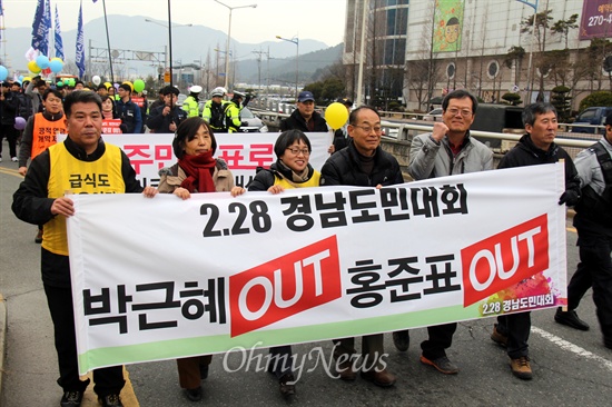 28일 오후 창원종합버스버티널 앞에서 열린 경남도민대회를 마친 뒤, 김영만 6.15경남본부 상임대표와 김재명 민주노총 경남본부장, 하원오 전농부경연맹 의장, 김미선 무상급식경남운동본부 공동대표 등이 "박근혜 퇴진, 홍준표 퇴진"이라고 쓴 펼침막을 들고 새누리당 경남도당 앞까지 거리행진하고 있다.