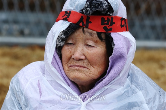 월성원전 인근 봉길마을 한 주민이 3일 오후 경북 경주 한국수력원자력 월성원자력본부 정문 앞에서 열린 월성원전1호기 수명연장 결정에 대한 항의 집회에서 비를 맞으며 바닥에 앉아 있다.