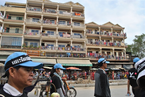 거리행진 하는 행사 참여자들과 이를 지켜보는 프놈펜 시민들의 모습