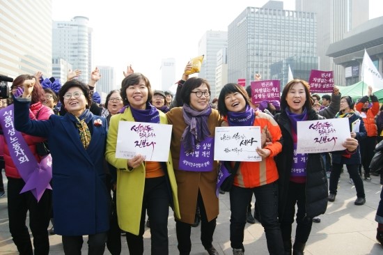 이미경 새정치민주연합 의원(가운데)과 대회에 참가한 여성단체 회원들이 어깨를 나란히 하며 웃고 있다.