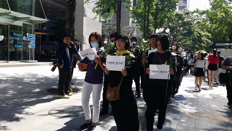 2014년 5월 3일에 있었던 "가만히 있으라" 추모 침묵행진에서 용혜인씨가 국화와 손피켓을 손에 들고 행진하고 있다.